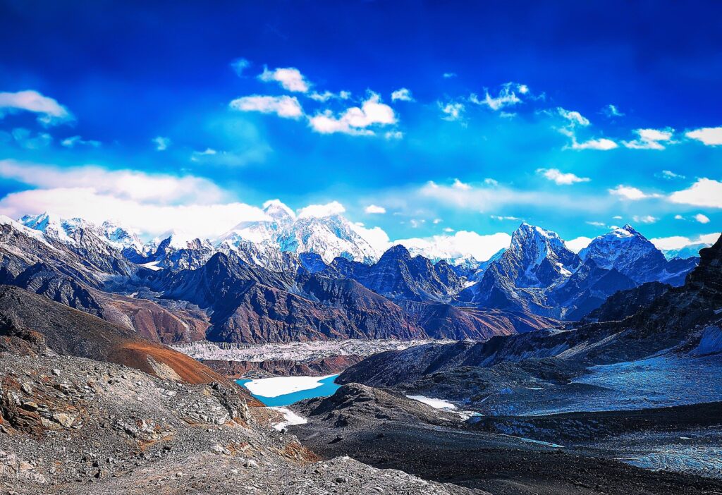 High-altitude glacial valley with a turquoise lake below snow-capped Himalayan peaks
