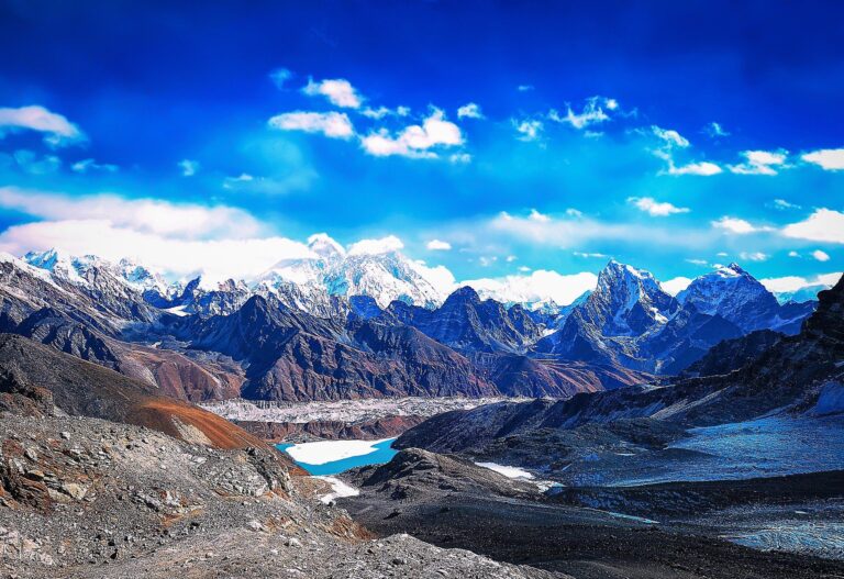 High-altitude glacial valley with a turquoise lake below snow-capped Himalayan peaks