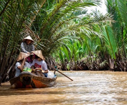 Explore the vibrant scenery on a traditional boat ride through the Mekong Delta's palm-lined waterways.