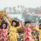 four women holding hands while jumping